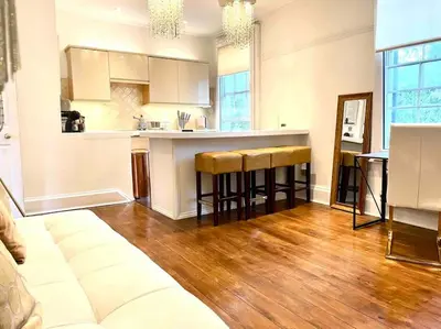 a kitchen with a counter and stools in a room at EMMANUEL HOUSE LOVELY 1 - BEDROOM APT IN HISTORICAL BUILDING CENTRAL CAMBRIDGE in Cambridge