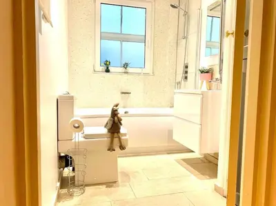 a bathroom with a tub and a teddy bear sitting on the sink at EMMANUEL HOUSE LOVELY 1 - BEDROOM APT IN HISTORICAL BUILDING CENTRAL CAMBRIDGE in Cambridge