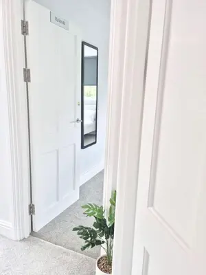 a hallway with a mirror and a potted plant at Hyland Apartment by CityNest in Chelmsford
