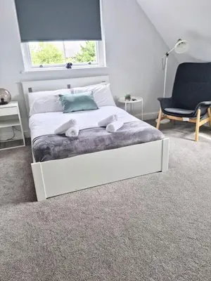 a white bed in a room with a window at Hyland Apartment by CityNest in Chelmsford
