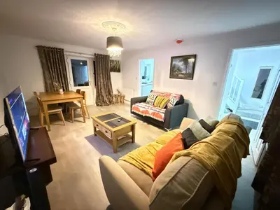 a living room with a couch and a table at Comfy, king bed families & Contractors welcome in St Ives