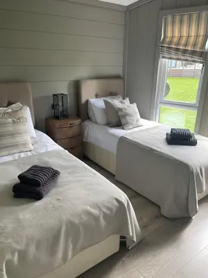 a bedroom with two beds and a window at Glasshouse hot tub lodge in Hengrave