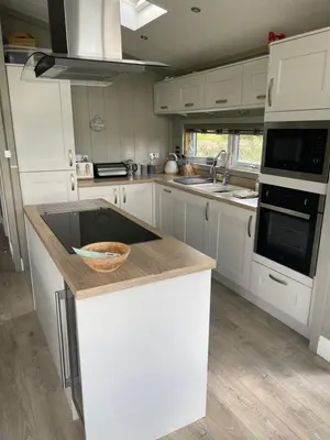 a kitchen with white cabinets and a bowl on a counter at Glasshouse hot tub lodge in Hengrave