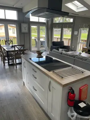 a kitchen and living room with a couch and a table at Glasshouse hot tub lodge in Hengrave
