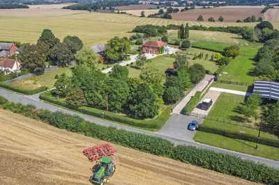 an overhead view of a person riding a combine harvesting a field at The Stables Rectory Farm in Halstead