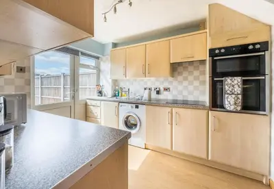 a kitchen with wooden cabinets and a counter top at Morden holiday in Basildon