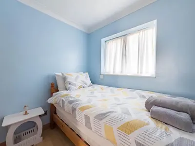 a bedroom with blue walls and a bed with a window at Morden holiday in Basildon