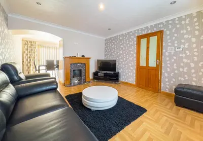 a living room with a leather couch and a coffee table at Morden holiday in Basildon