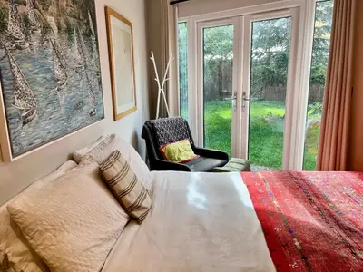 a bedroom with a bed and a chair and a window at Modern, Gr Floor 1 bed, bathroom, garden & private entry with Free Parking in Cambridge