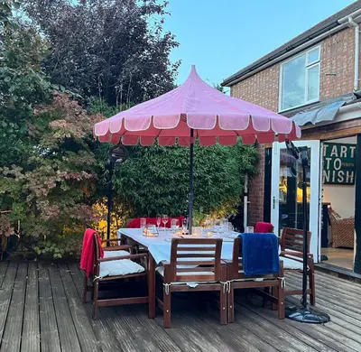 a table with a pink umbrella on a deck at Modern, Gr Floor 1 bed, bathroom, garden & private entry with Free Parking in Cambridge