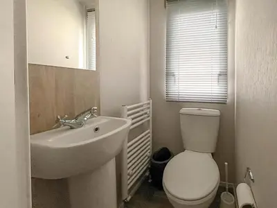 a white bathroom with a toilet and a sink at Beautiful 8 Berth Caravan With Decking At Naze Marine Park, Essex Ref 17184P in Walton-on-the-Naze