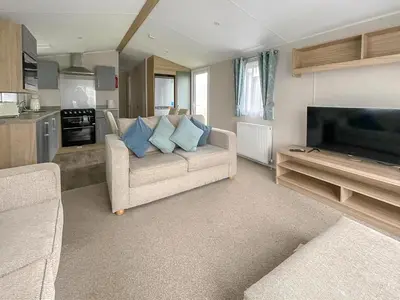 a living room with a couch and a flat screen tv at Beautiful 8 Berth Caravan With Decking At Naze Marine Park, Essex Ref 17184P in Walton-on-the-Naze