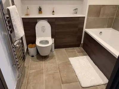 a bathroom with a toilet and a sink and a tub at Raphvin Apex Abode - Two bedroom apartmentparking in Harlow