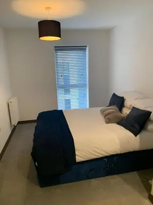 a large bed in a room with a window at Raphvin Apex Abode - Two bedroom apartmentparking in Harlow