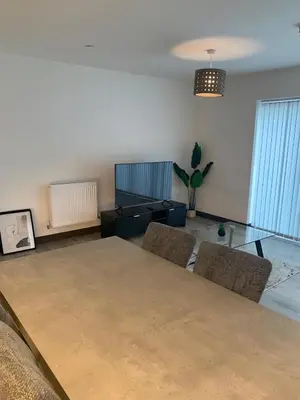a living room with a table and chairs at Raphvin Apex Abode - Two bedroom apartmentparking in Harlow