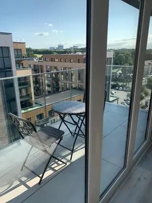 a chair on a balcony with a view of a city at Raphvin Apex Abode - Two bedroom apartmentparking in Harlow