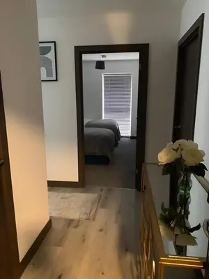 a hallway with a mirror and a bedroom with a bed at Raphvin Apex Abode - Two bedroom apartmentparking in Harlow