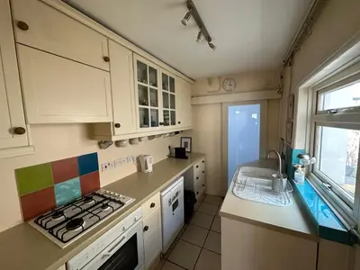 a kitchen with white cabinets and a stove top oven at Beautiful Victorian house in central Cambridge in Cambridge