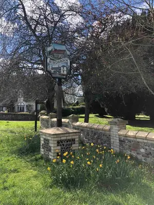 a sign on a pole in a field with flowers at The Cottage in Birdbrook