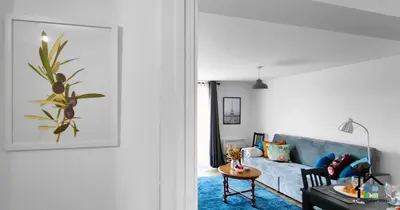 a living room with a blue couch and a table at R&O Property Experts - Riverside - 2 & 3 BR - Flat Walk to Centre with open Parking in Cambridge