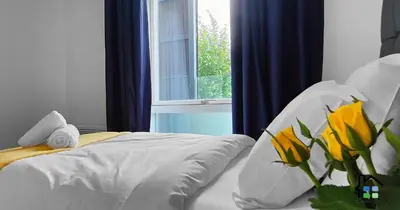 a bedroom with a bed with yellow flowers and a window at R&O Property Experts - Riverside - 2 & 3 BR - Flat Walk to Centre with open Parking in Cambridge