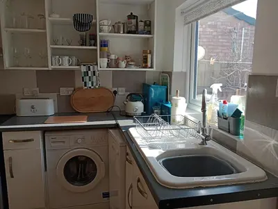 a kitchen with a sink and a washing machine at Bellevue cottage in Wicken