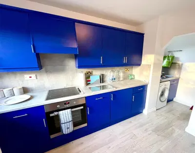 a blue kitchen with a sink and a dishwasher at Large 5 bed detached house near Stansted Airport with Parking for 2 vehicles! Stansted Stays in Stansted Mountfitchet