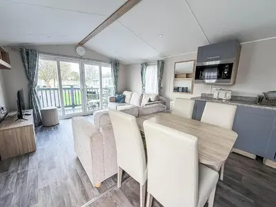 a kitchen and living room with a table and chairs at Modern 8 Berth Caravan With Decking At Naze Marine Park, Essex Ref 17145P in Walton-on-the-Naze