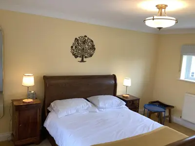 a bedroom with a bed with a tree on the wall at Peaceful house ideal for dogs lovely location in Aldeburgh
