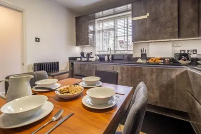 a kitchen with a wooden table with bowls of food on it at Crown Street 4 in Bury Saint Edmunds
