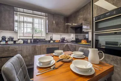 a kitchen with a wooden table with dishes on it at Crown Street 4 in Bury Saint Edmunds