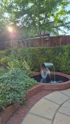 a fountain in the middle of a yard with a brick path at Fly By - Duxford close to IWM & Wellcome Genome Campus in Duxford