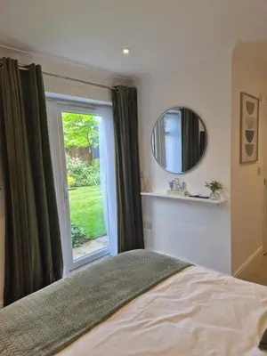 a bedroom with a window and a bed and a mirror at Fly By - Duxford close to IWM & Wellcome Genome Campus in Duxford