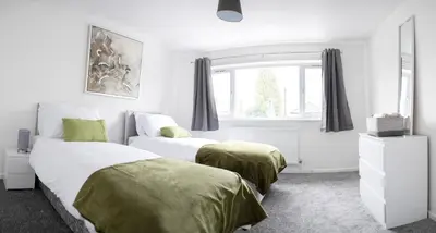 two beds in a white bedroom with a window at Mowbray Quarters of Cambridge in Cambridge