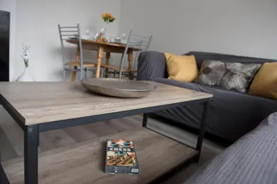 a living room with a table and a blue couch at Mowbray Quarters of Cambridge in Cambridge