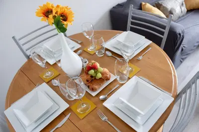 a table with plates and glasses and a vase of flowers at Mowbray Quarters of Cambridge in Cambridge