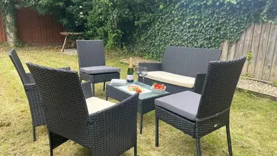 a group of chairs and a table with a bottle of wine at Mowbray Quarters of Cambridge in Cambridge
