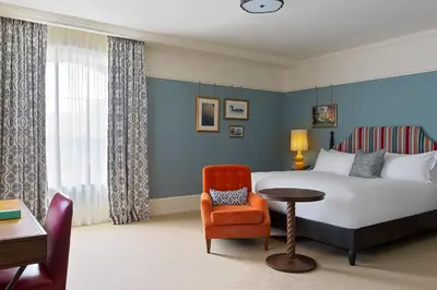 a hotel room with a bed and a chair at University Arms, Autograph Collection in Cambridge