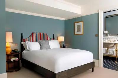 a bedroom with a large bed with blue walls at University Arms, Autograph Collection in Cambridge