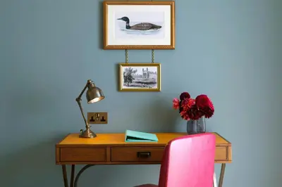a desk with a pink chair and a desk with a lamp at University Arms, Autograph Collection in Cambridge