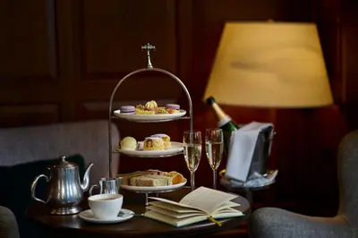 a table with a tray of food and wine glasses at University Arms, Autograph Collection in Cambridge