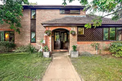 a brick house with a door and a sidewalk at Spring Close in Colchester