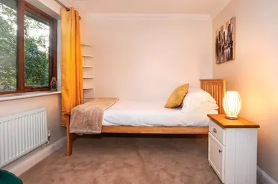 a small bedroom with a bed and a window at Spring Close in Colchester
