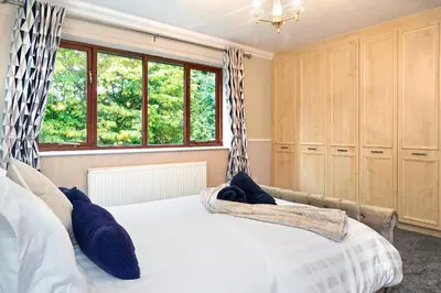 a bedroom with a bed with blue pillows on it at Spring Close in Colchester