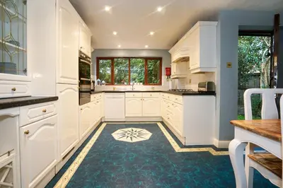 a kitchen with white cabinets and a blue floor at Spring Close in Colchester