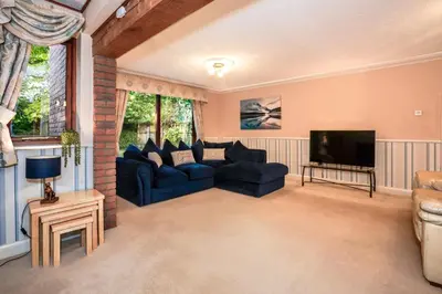 a living room with blue couches and a tv at Spring Close in Colchester
