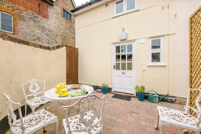 a patio with two white chairs and a table at No. 10, The Cottage in Framlingham