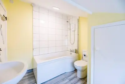 a bathroom with a tub and a toilet and a sink at No. 10, The Cottage in Framlingham