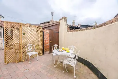 a patio with a table and chairs and a fence at No. 10, The Cottage in Framlingham