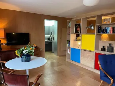 a living room with a table and a room with a tv at Seahorse Studio, Aldeburgh in Aldeburgh